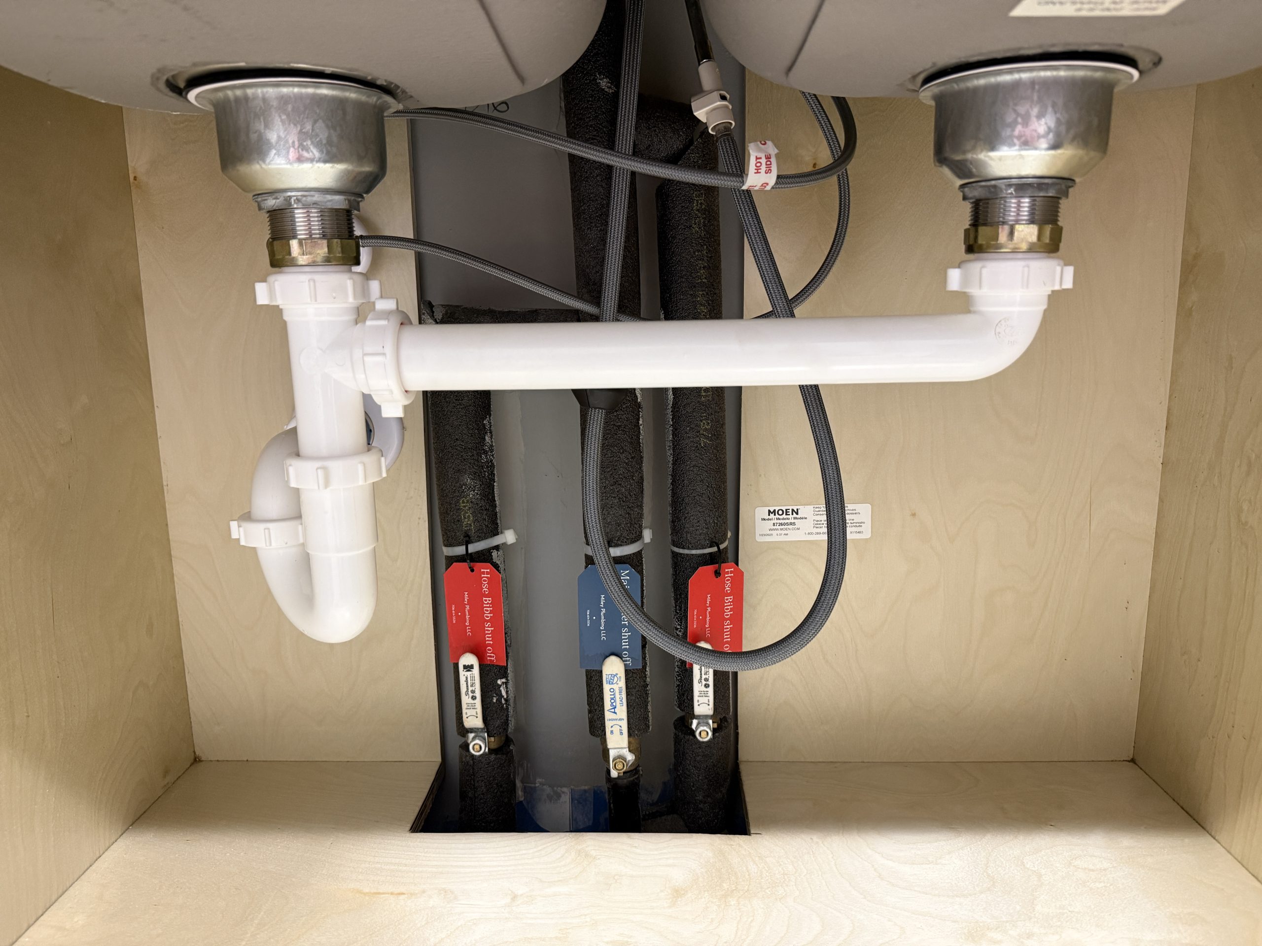 New drain and supply lines under a double kitchen sink