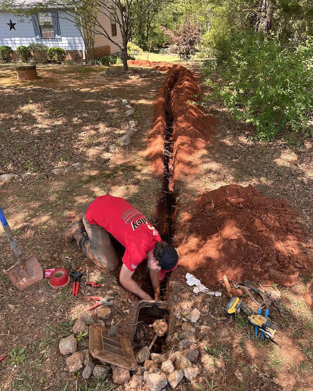 Plumber digging a trench to replace a water service line