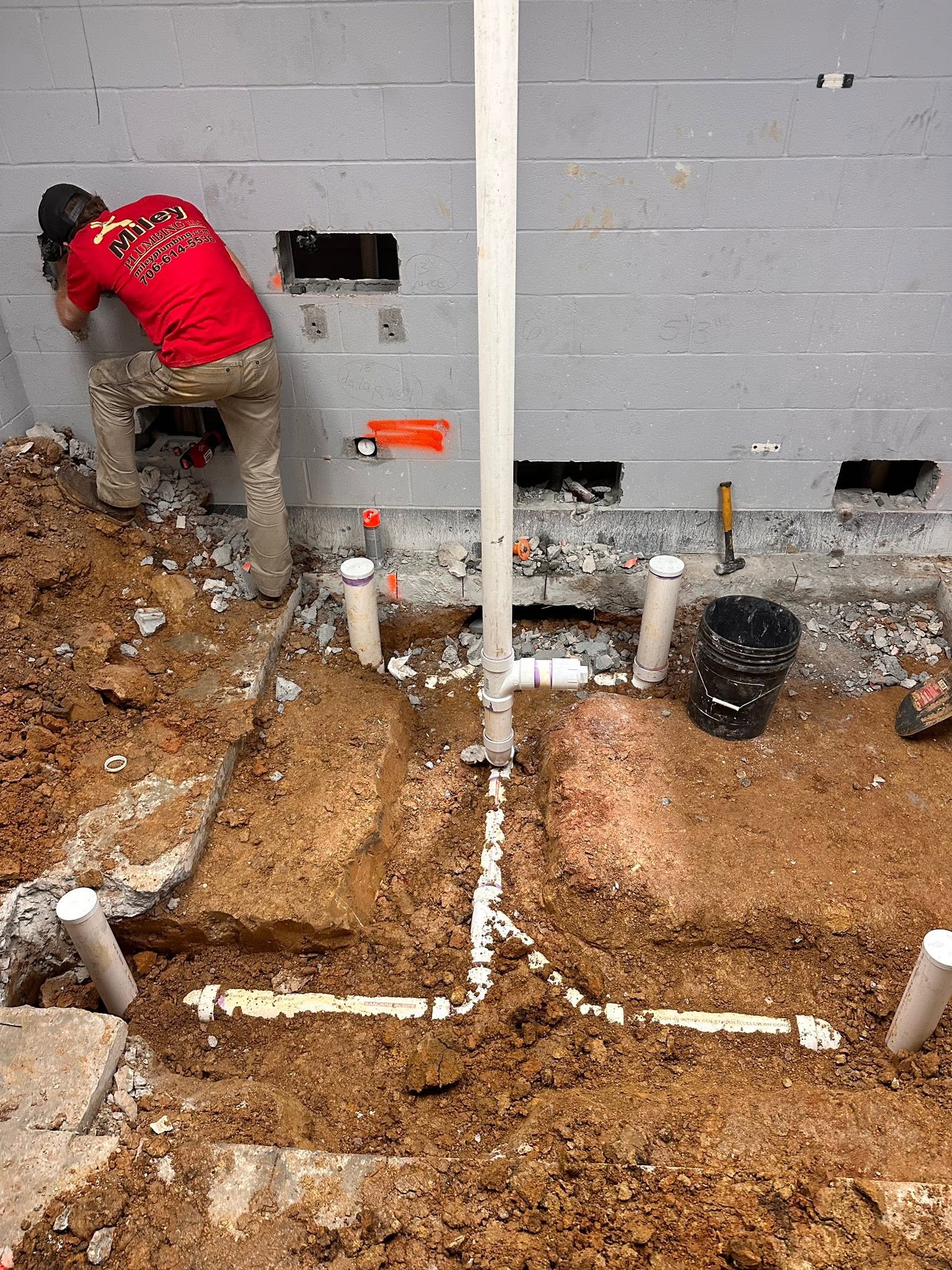 Plumber installing underground drain lines